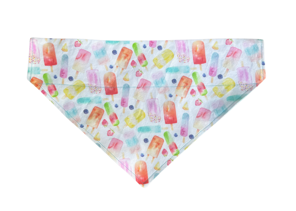 A triangular pet bandana with a colorful watercolor popsicle print on a white background, shown flat against a white backdrop.